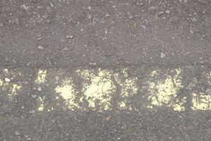 il vecchio manto stradale ha linee gialle che si staccano. foto
