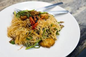 Vermicelli di riso saltati in padella con carne di maiale fritta foto