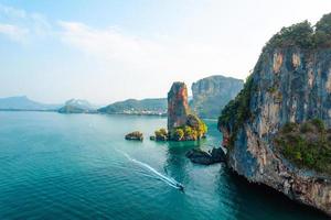 vista mare e isole rocciose con una barca a coda lunga. foto