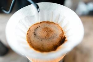 gocciolare il caffè, versare l'acqua calda nel bollitore nel caffè, preparare il caffè foto