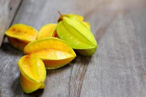 frutta stella gialla matura o mela stellata, carambole su pavimento in legno foto