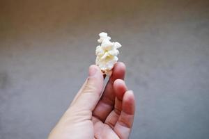 mano che tiene deliziosi popcorn dolci in sacchetti di plastica. foto