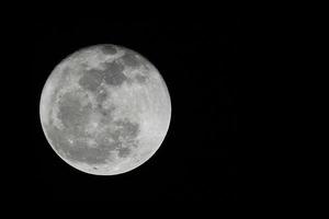 luce di alimentazione della super luna piena nella notte nera scura e mostra lo spazio della trama della superficie lunare. foto