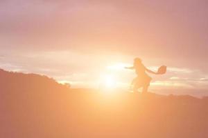 silhouette di donna che prega su sfondo bellissimo cielo foto