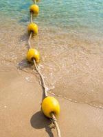 boa galleggiante e corda che dividono l'area sulla spiaggia foto