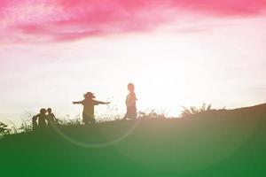 sagoma di bambini felici e tempo felice tramonto foto