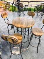 sedia in legno e tavolo circolare sul pavimento di cemento vicino alla terrazza. foto