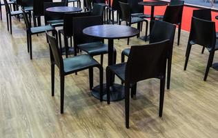 sedia nera moderna e set da tavola in legno circolare. foto