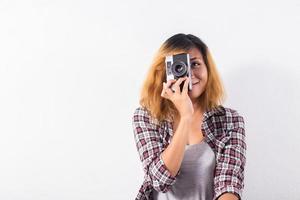 giovane bella donna hipster con una vecchia macchina fotografica retrò. foto