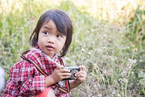 la bambina fotografa il fiore all'aperto foto