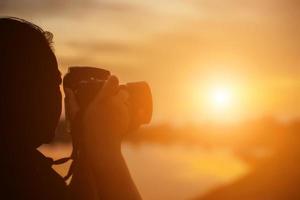 fotografo naturalista femminile con fotocamera digitale sulla montagna foto