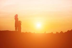 la madre incoraggiava la figlia a uscire dall'ombra al tramonto. foto