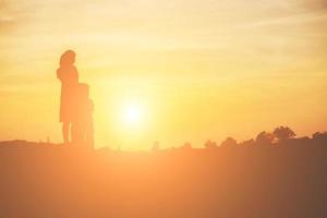 la madre incoraggiava la figlia a uscire dall'ombra al tramonto. foto