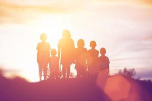 sagoma di bambini felici e tempo felice tramonto foto