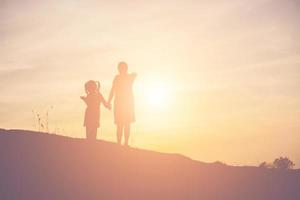 la madre incoraggiava la figlia a uscire dall'ombra al tramonto. foto