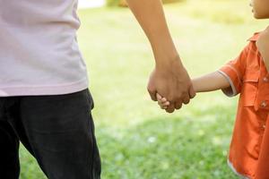 a il genitore tiene la mano di un bambino piccolo foto