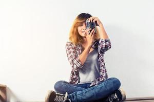 giovane bella donna hipster con una vecchia macchina fotografica retrò. foto