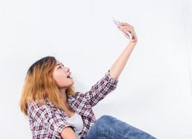 felice giovane donna hipster prendendo selfie foto su smartphone su sfondo bianco.