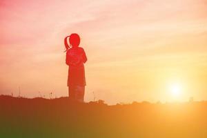 sagoma del bambino, momenti di gioia del bambino. sul tramonto della natura foto