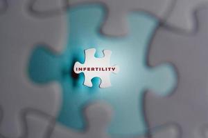 parola di infertilità su pezzi di un puzzle isolati su sfondo blu. trattamento IVF. foto