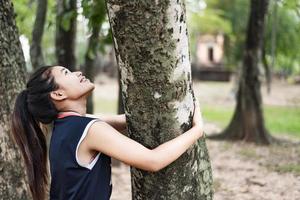 giovane donna che abbraccia un grande albero, ama il concetto di natura. foto