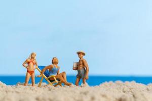 persone in miniatura famiglia felice rilassante sulla spiaggia foto