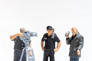 giornalista in miniatura con microfono e cameraman che intervista gli agenti di polizia foto