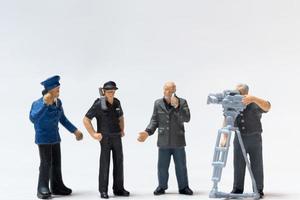 giornalista in miniatura con microfono e cameraman che intervista gli agenti di polizia foto