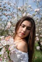 giovane donna caucasica godendo la fioritura di un melo foto