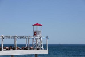 postazione di salvataggio, torre di salvataggio sulla spiaggia sullo sfondo del mare e del cielo. foto