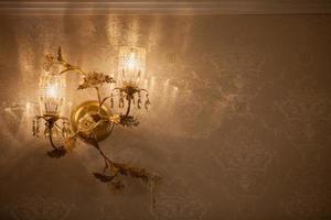 lampada da parete su una parete con carta da parati dorata interior design foto