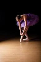 giovane ballerina femmina regolando le sue scarpe
