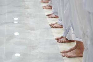 i piedi degli uomini asiatici sono in fila con tutti i pantaloni bianchi. foto
