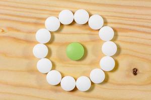 le pillole verdi sono in un cerchio di pillole bianche. foto
