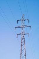 torre di trasmissione elettrica su sfondo verticale cielo blu. foto
