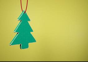 vecchio albero di Natale in legno giocattolo su sfondo giallo foto