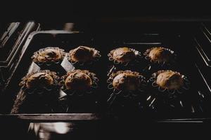 primo piano di muffin al cioccolato che cuociono in forno