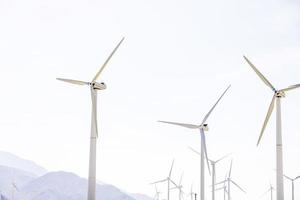 turbine eoliche che girano con il vento in mezzo a un cielo limpido foto