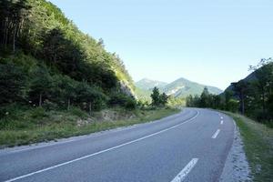 strada di montagna nelle Alpi francesi in una soleggiata mattina d'estate, bellissimo paesaggio naturale per il design di viaggio, strada rurale vuota con paesaggi pittoreschi foto