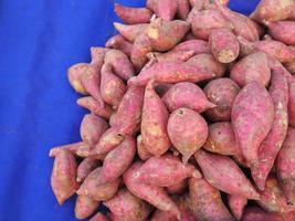 mucchio di patate dolci viola fresche organiche per la vendita nel mercato foto
