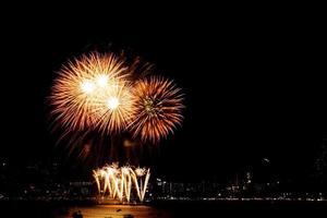 molti fuochi d'artificio lampeggianti con sfondo paesaggio urbano notturno festeggiano il nuovo anno. foto