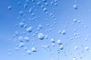 gocce di pioggia che scendono da una finestra in una vista ravvicinata. foto