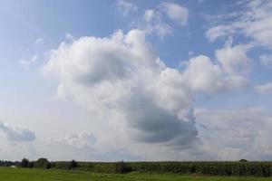 belle formazioni di nuvole bianche e soffici in un cielo estivo blu intenso foto