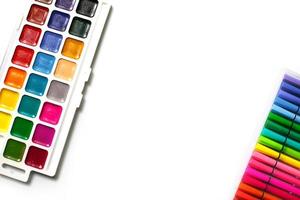 una tavolozza di acquerelli a colori con pennelli e pennarelli su sfondo bianco con spazio per il testo. foto