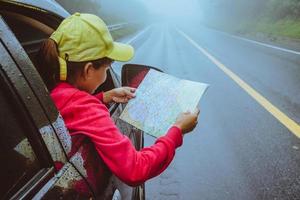 le donne asiatiche viaggiano rilassandosi durante le vacanze. viaggiare in parcheggio. visualizza la mappa per le escursioni nella natura durante la stagione delle piogge. foto