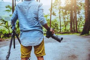 fotografo uomo asiatico viaggio natura. viaggiare rilassati. studio della natura. al parco pubblico in estate. parco nazionale doi inthanon in thailandia. foto