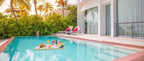 colazione in piscina, colazione galleggiante in resort tropicale. tavolo rilassante nell'acqua calma della piscina, colazione sana e piatto di frutta presso la piscina del resort. dieta estiva esotica. stile di vita da spiaggia tropicale foto