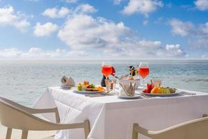 cibo per la colazione di lusso sul tavolo bianco, con bellissimo sfondo vista mare tropicale, vacanze estive al mattino e concetto di vacanza romantica, viaggi di lusso e stile di vita foto