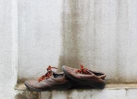 vecchie scarpe da ginnastica sulla parete di fondo. foto