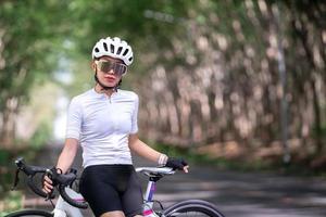 l'atleta di ciclismo donna felice si prepara per il giro in bicicletta su strada, su strada, ad alta velocità per l'esercizio hobby e la competizione in tour professionali foto